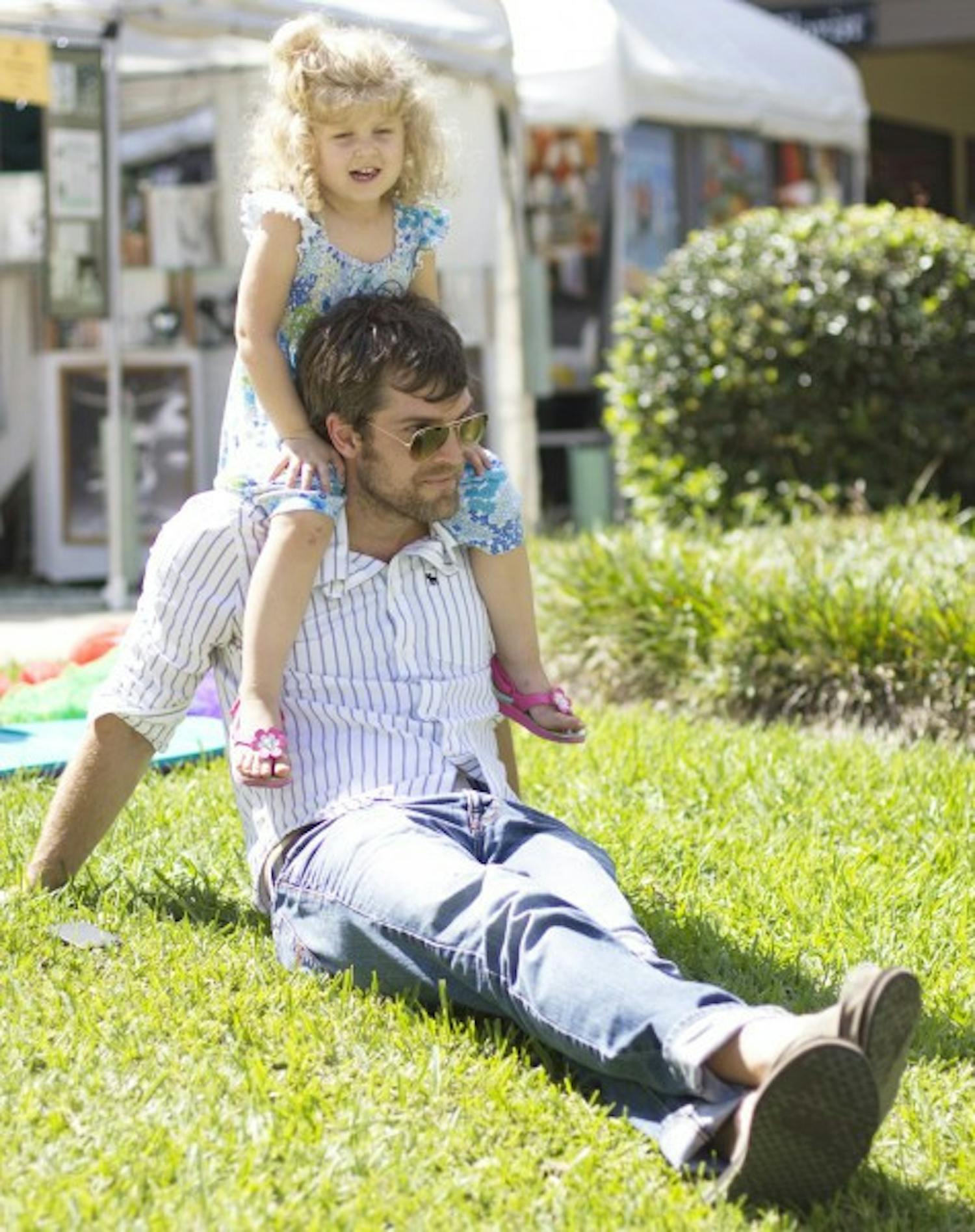 Robert Privette, 35, and his daughter Elizabeth, 2, relax in the sun together at the Gainesville Fine Arts Association's 28th annual GFAA Art Festival at Thornebrook over the weekend at 2441 NW 43rd Street.