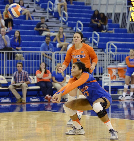 Sophomore outside hitter Noami Santos-Lamb (17) squats to bump the ball during Florida’s 3-0 victory against New Orleans on Friday in the O’Connell Center. Florida won all three of its weekend matches.