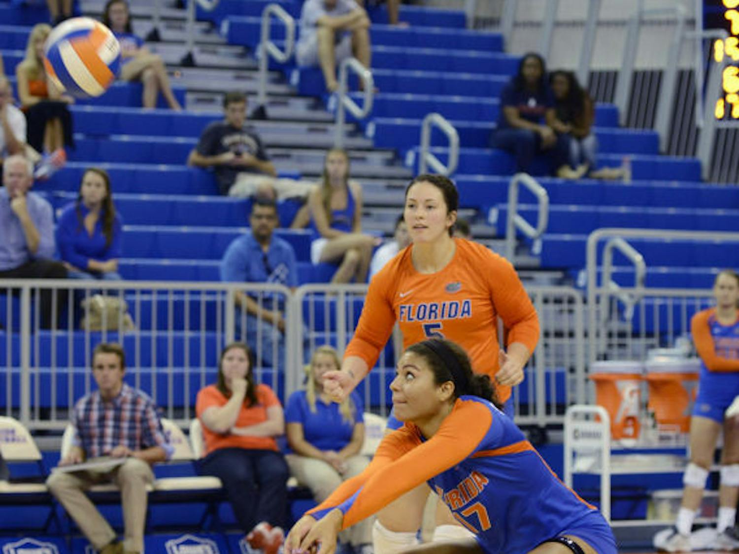 Sophomore outside hitter Noami Santos-Lamb (17) squats to bump the ball during Florida’s 3-0 victory against New Orleans on Friday in the O’Connell Center. Florida won all three of its weekend matches.