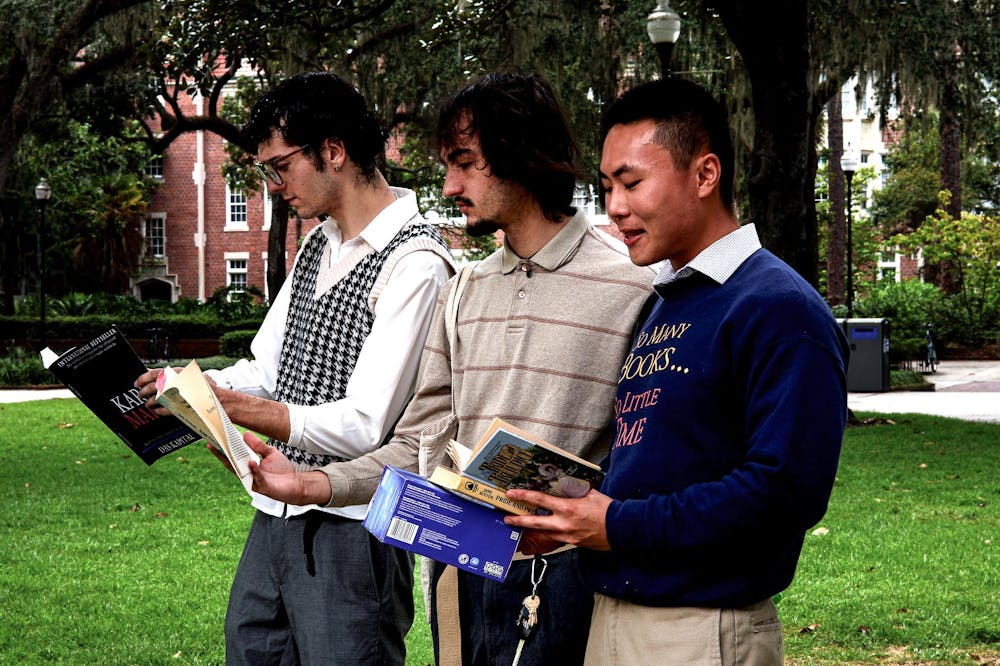 Three performative males reading books at Plaza of the Americas on Monday, Sept. 1, 2025.