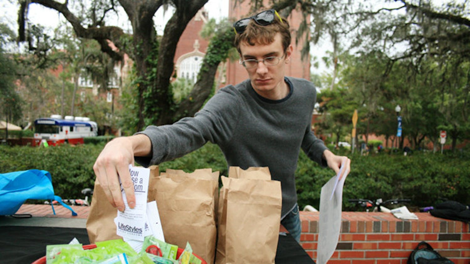 A student distributes free condoms from GatorWell on Turlington Plaza.