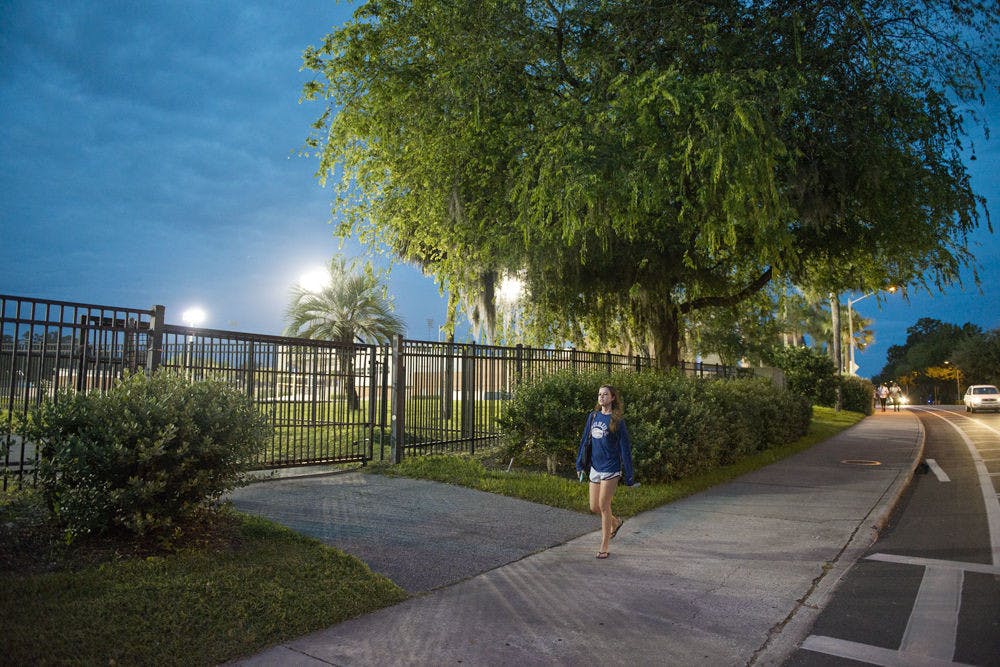 UF psychology freshman Kelly Delgado, 18, walks by James G. Pressly Stadium on Monday night.