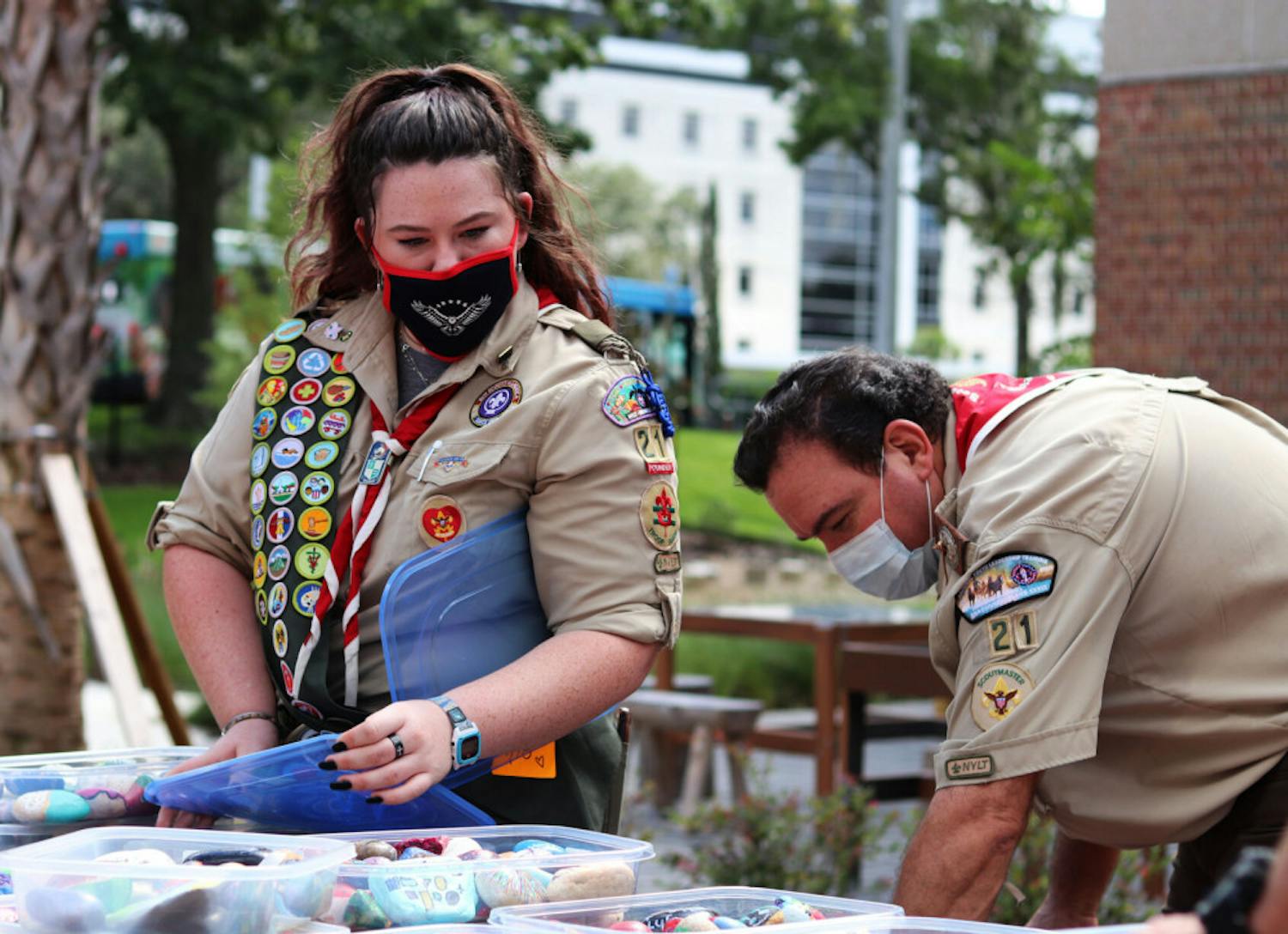 Olivia Foli, 16, an eagle scout who helped start Gainesville’s first female troop, and her dad, Randy Foli, take some of the 676 painted healing stones out of its containers at the UF Health Children's Healing Garden on Friday, Sept. 18, 2020.