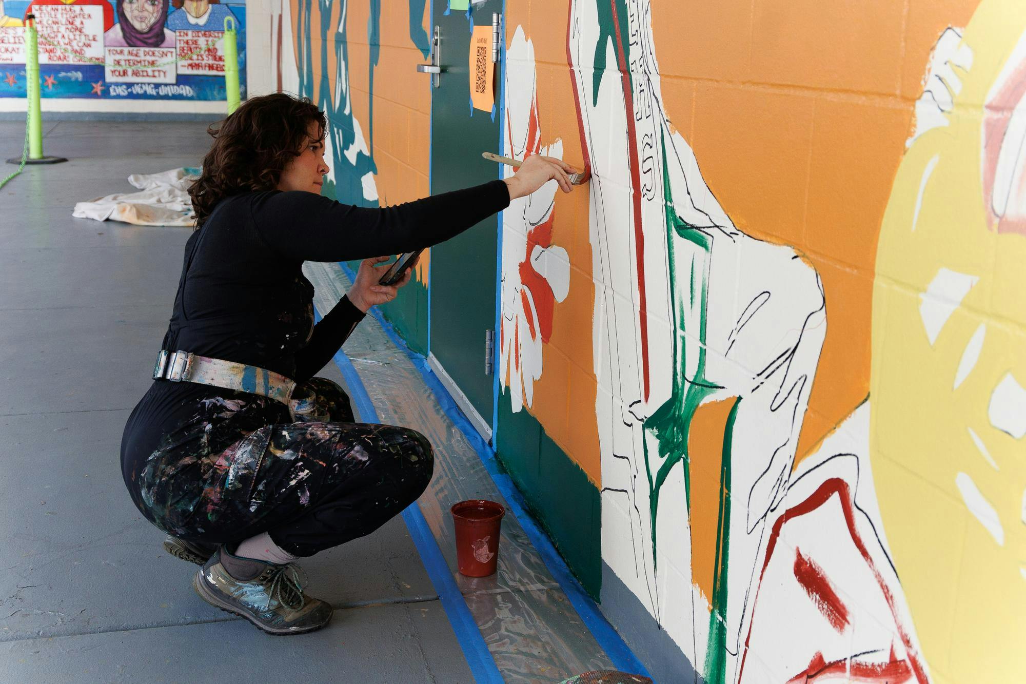 Jenna Horner, program director of Mindful Messages, paints a mural at East Side High School in Gainesville, Fla., Wednesday, March 11, 2026. 