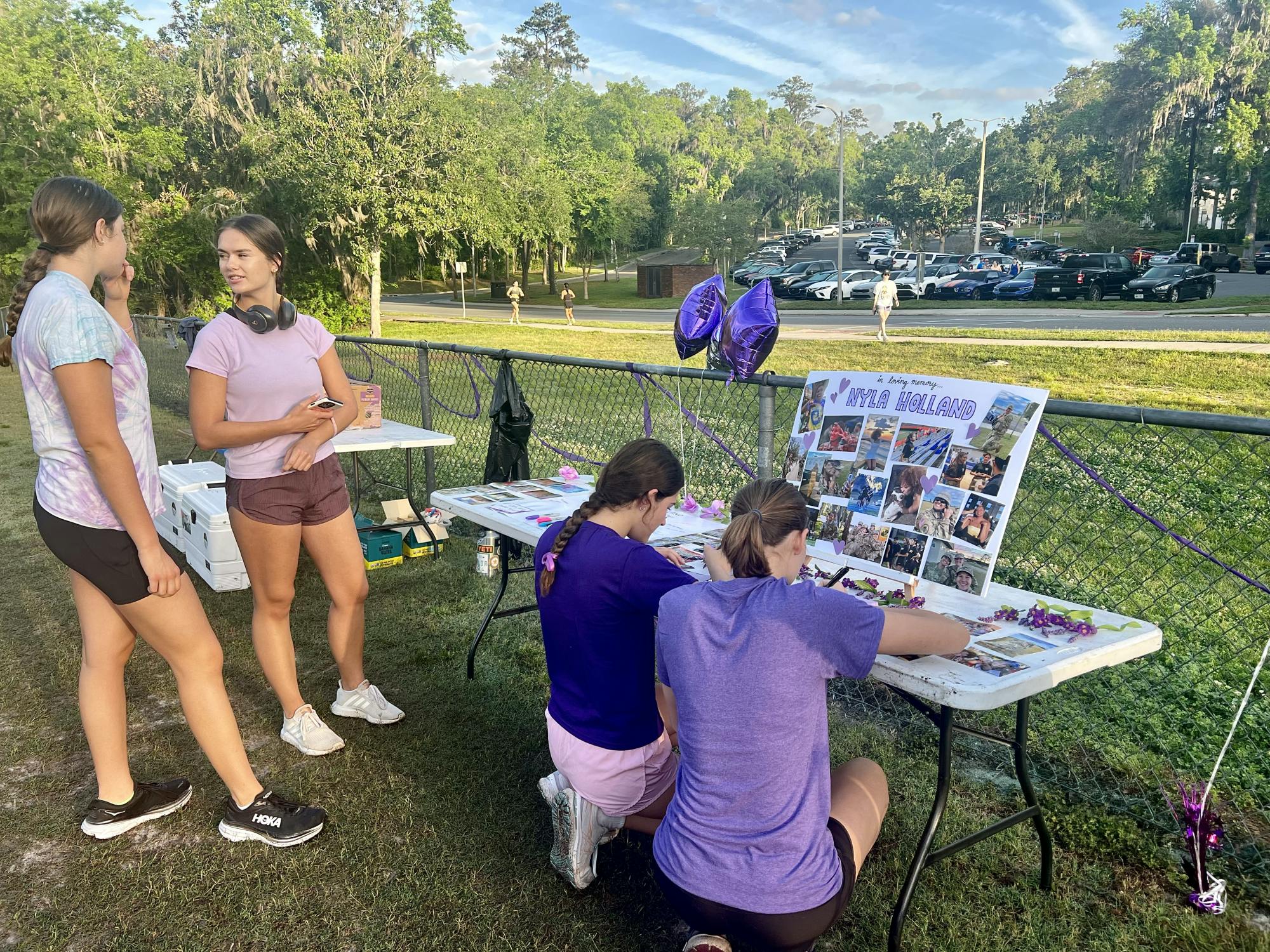 Participants of the 5K run for Nyla Holland write notes to her family while looking at past photos on Saturday, April 5, 2025.