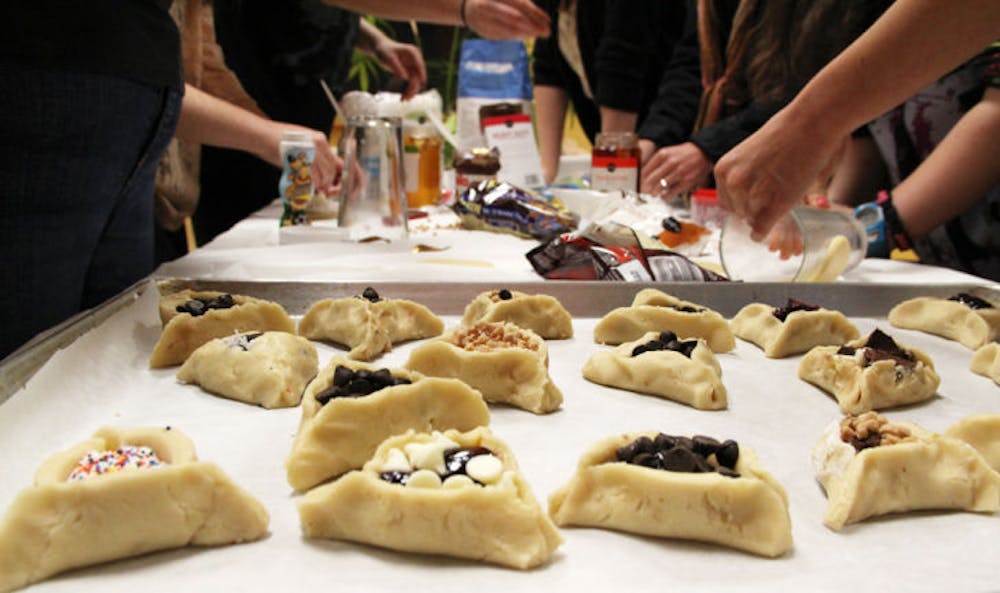 <p>Team Koach prepares hamantaschen in a bake-off at UF Hillel on Wednesday. The cookies are filled with fruit, chocolate or other ingredients.</p>