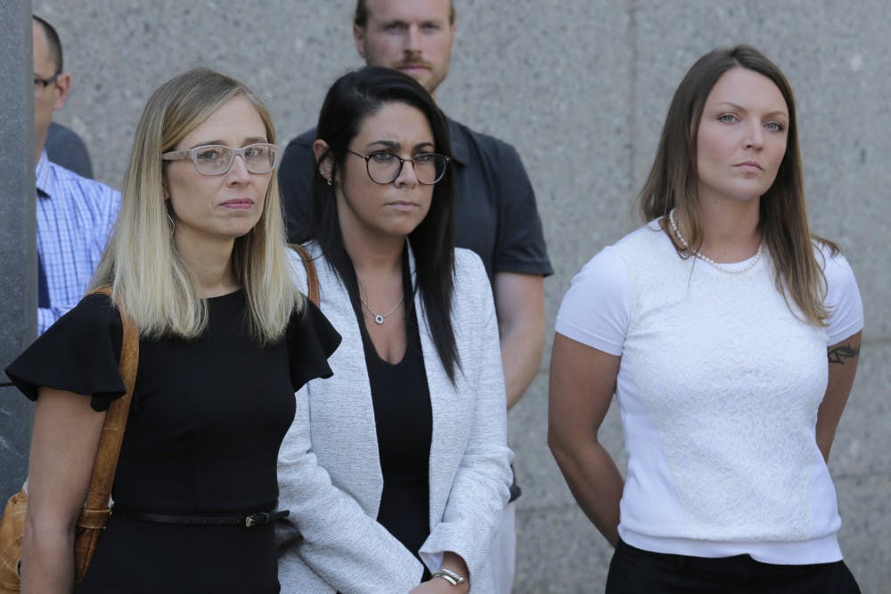 Annie Farmer, left, and Courtney Wild, right, accusers of Jeffery Epstein, stand outside the courthouse in New York, Monday, July 15, 2019. Financier Jeffrey Epstein will remain behind bars for now as a federal judge mulls whether to grant bail on charges he sexually abused underage girls.