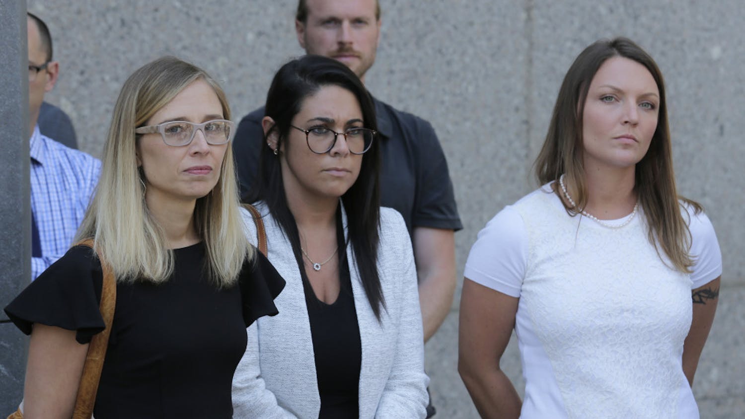 Annie Farmer, left, and Courtney Wild, right, accusers of Jeffery Epstein, stand outside the courthouse in New York, Monday, July 15, 2019. Financier Jeffrey Epstein will remain behind bars for now as a federal judge mulls whether to grant bail on charges he sexually abused underage girls.