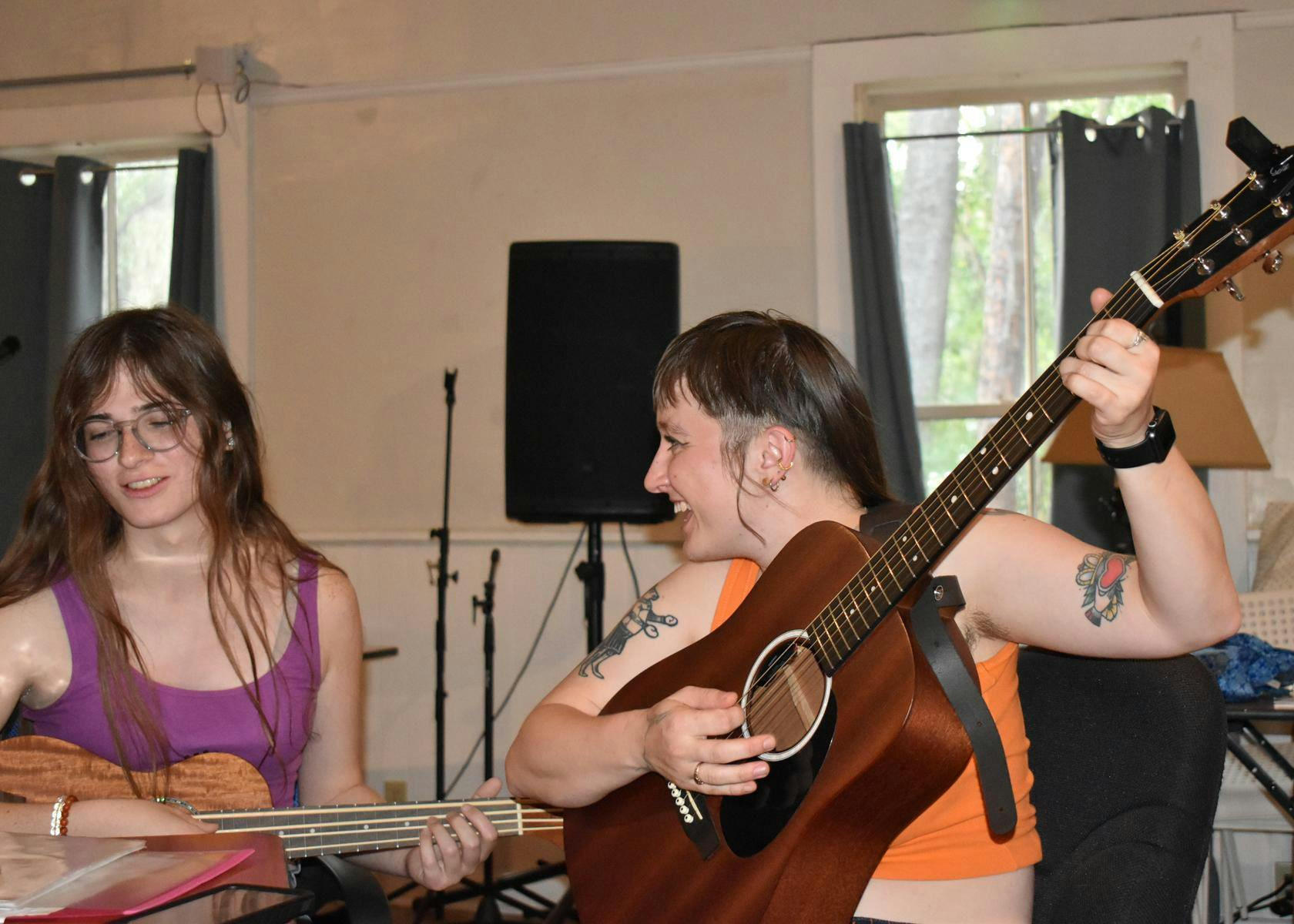 Helena Boehling smiles at Kay Hoff as they perform a song together at Nightjar Gallery & Studios, on Friday, May 22, 2026 in Gainesville, Florida.