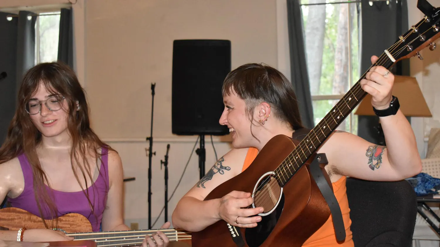 Helena Boehling smiles at Kay Hoff as they perform a song together at Nightjar Gallery & Studios, on Friday, May 22, 2026 in Gainesville, Florida.