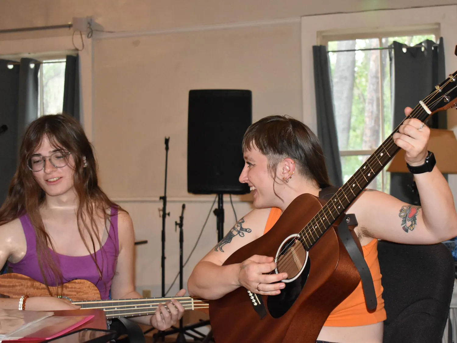 Helena Boehling smiles at Kay Hoff as they perform a song together at Nightjar Gallery & Studios, on Friday, May 22, 2026 in Gainesville, Florida.