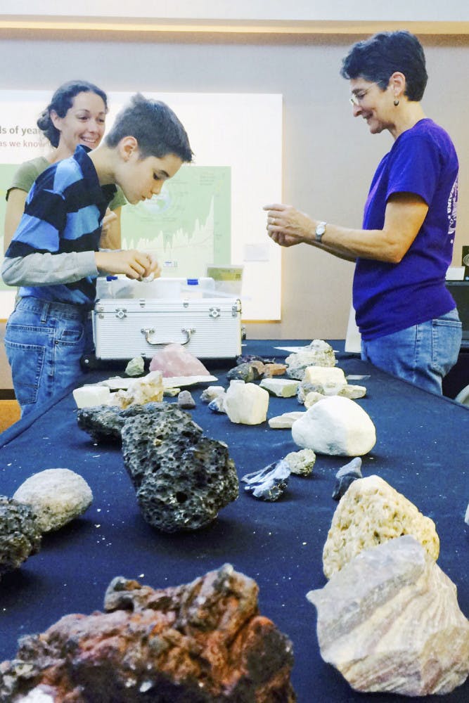 Jeremiah Clement (left), 11, shows his rock collection to Ellen Martin, a UF professor of palaeoceanography and paleoclimatology, in the Florida Museum of Natural History as part of the “Ask a Scientist,” event Sunday afternoon. A preview of next week’s “Can You Dig It?” event, rock collectors were encouraged to bring their specimens in to be examined by geologists.
