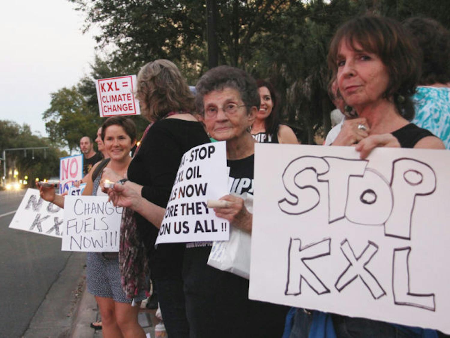 Members of the Gainesville community join together to call for President Barack Obama to stop the production of the Keystone XL Pipeline. The protest was held on Bo Diddley Community Plaza on Monday evening.