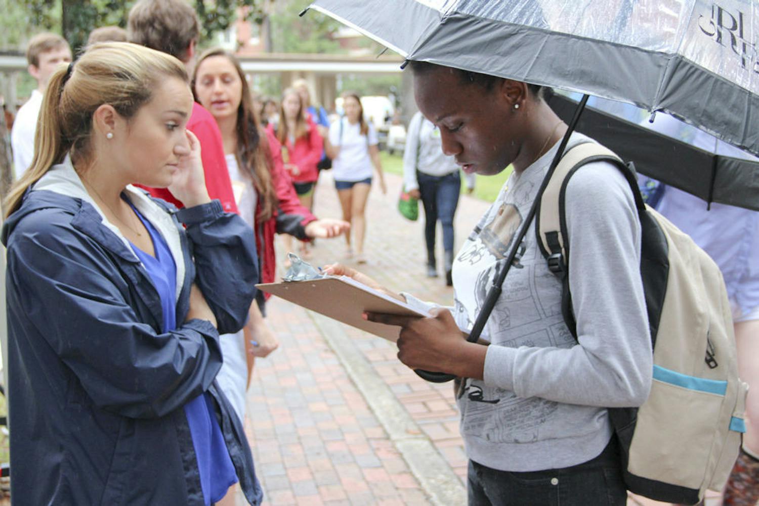 UF health science student Eunice Noel, 19, registers to vote while being assisted by Chomp the Vote Director, 21-year-old political science senior Kelly Vidal Tuesday morning on the Plaza of the Americas.