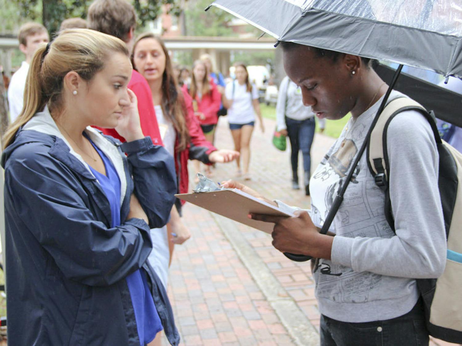 UF health science student Eunice Noel, 19, registers to vote while being assisted by Chomp the Vote Director, 21-year-old political science senior Kelly Vidal Tuesday morning on the Plaza of the Americas.