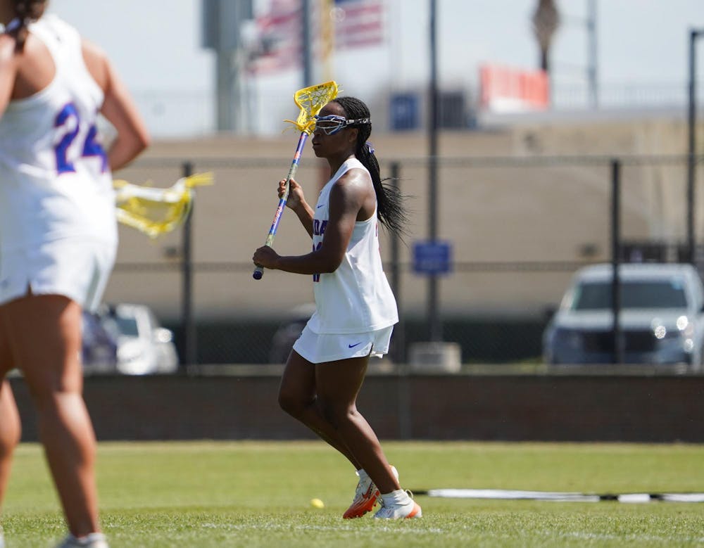 Clark Hamilton (21) looks to pass the ball in an NCAA women’s lacrosse game against Penn, Wednesday, March 11, 2026, in Gainesville, Fla.