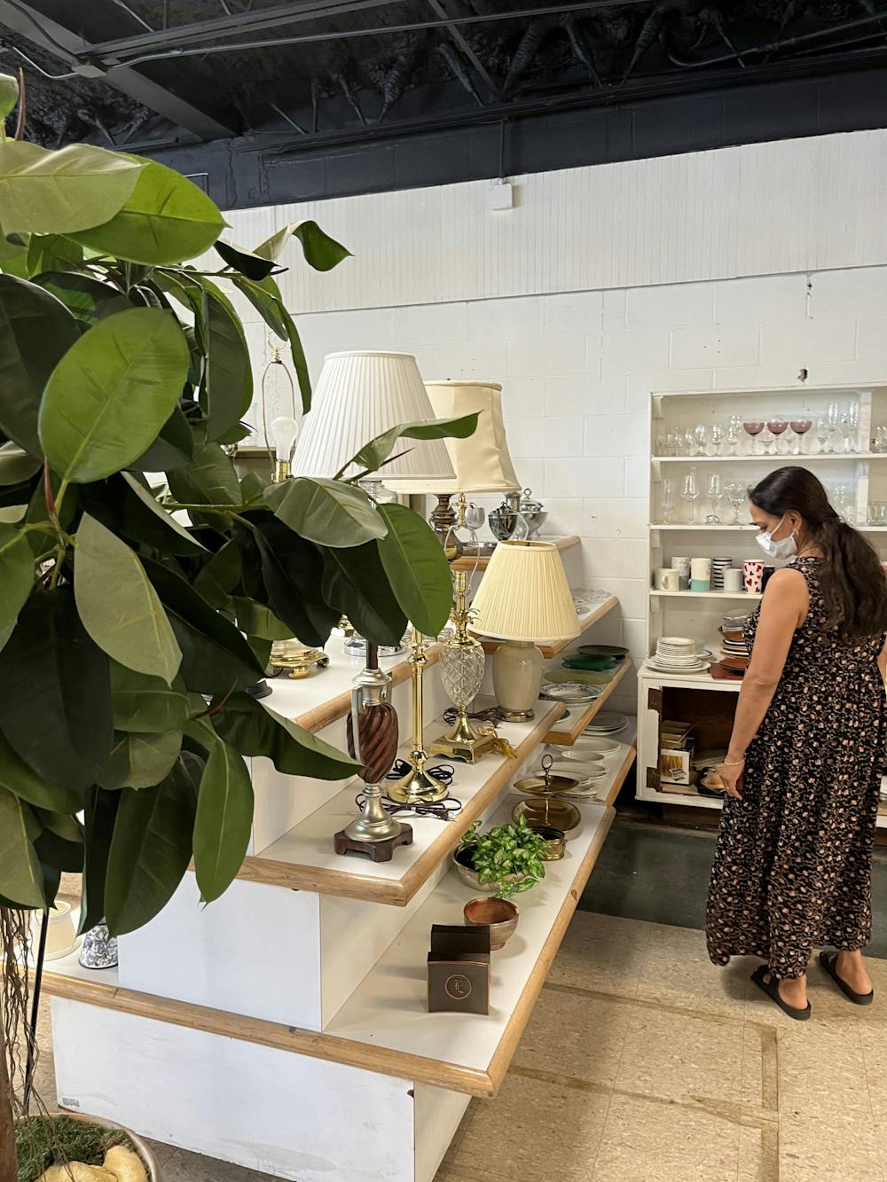 A customer examines a serving platter among the shelves of plates in the ReStore on Oct. 12. The store relocated on Sept. 28 to 2301 NW Sixth St. with a soft opening. It plans to hold a ribbon-cutting Nov. 5