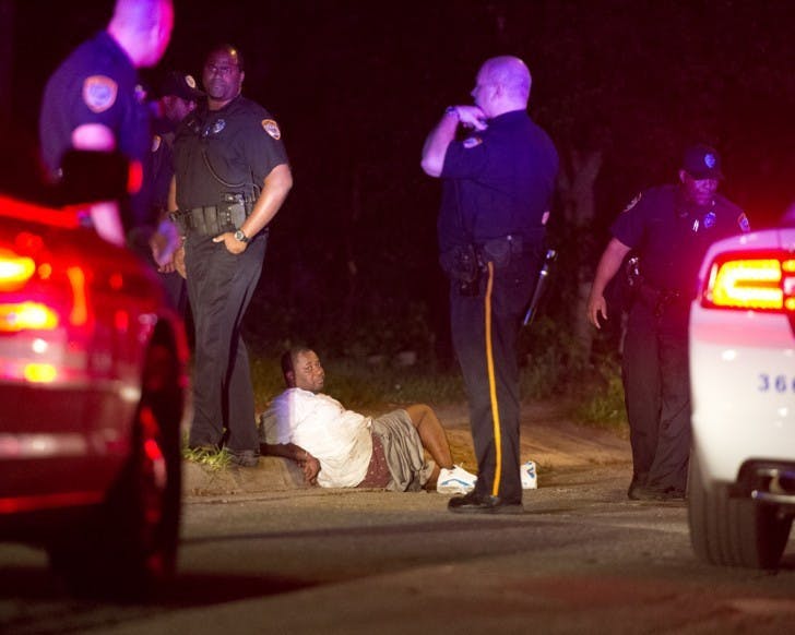 Gainesville Police officers await the arrival of medical workers on Northeast Sixth Street early Tuesday morning after arresting a suspect believed to be involved in a shooting near the Village Green and Forest Green apartment complexes.