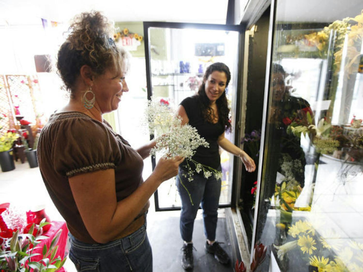 Jennifer Russo, 46, left, and Ridgely Fanara, 38, right, gather flowers for floral arrangements in Gainesville Floral Exchange, 635 NW 13th Street, Suite C, Tuesday afternoon.