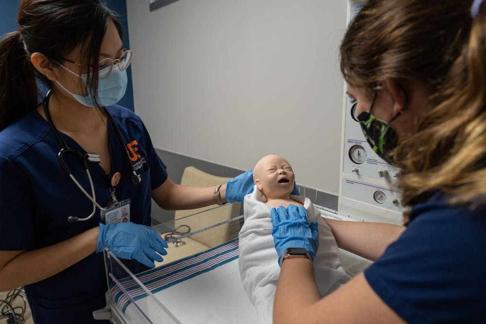 Two UF nursing students carrying out newborn assessment in one of the new simulation rooms at the College of Nursing. [Courtesy of Jesse Jones]