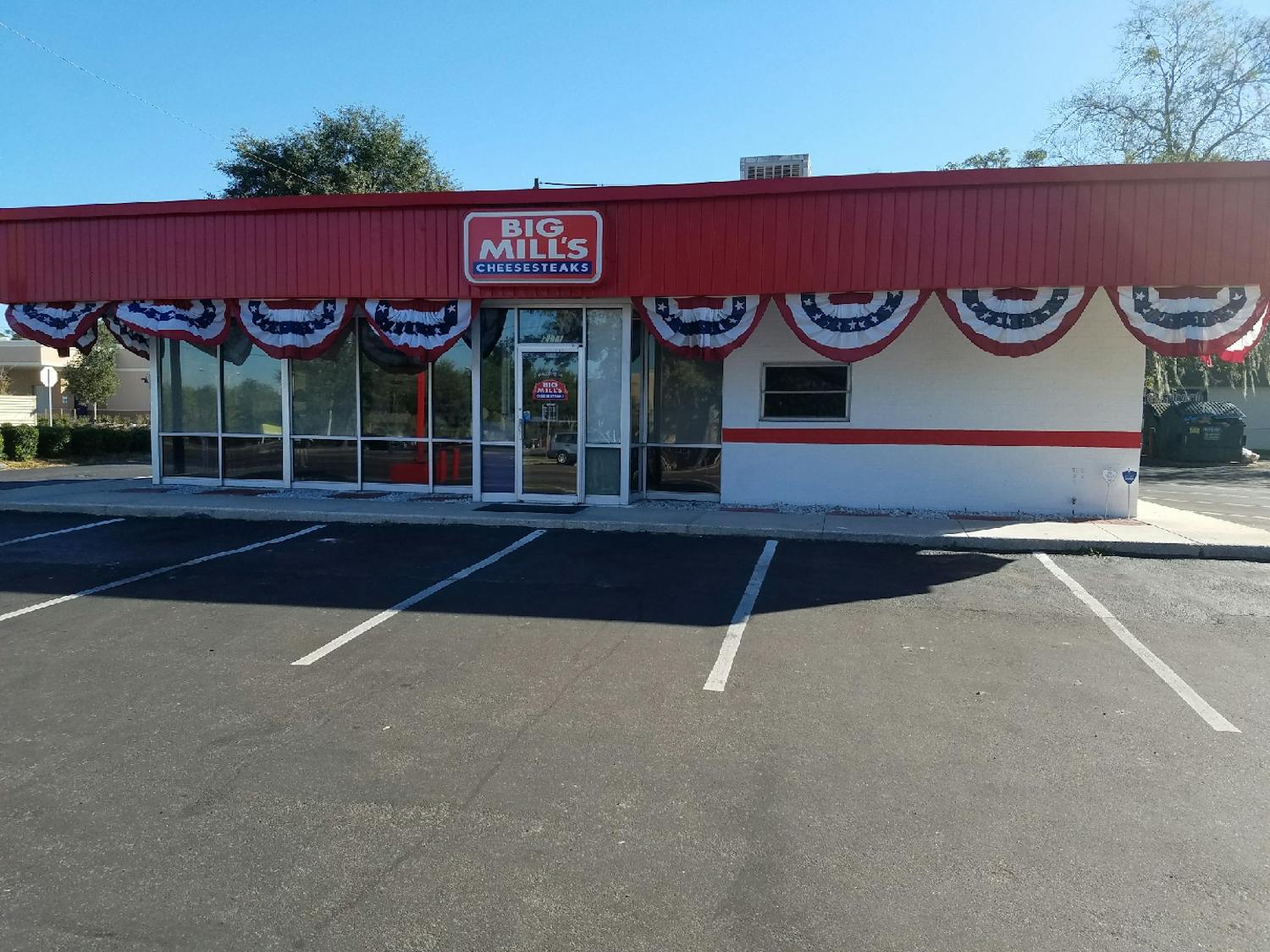 Red, white and blue buntings decorate Big Mill's Cheesesteaks, located at 2111 NW 13th St., before they were removed by owner Keith Miller on Wednesday. City officials told Miller his buntings were against code.
