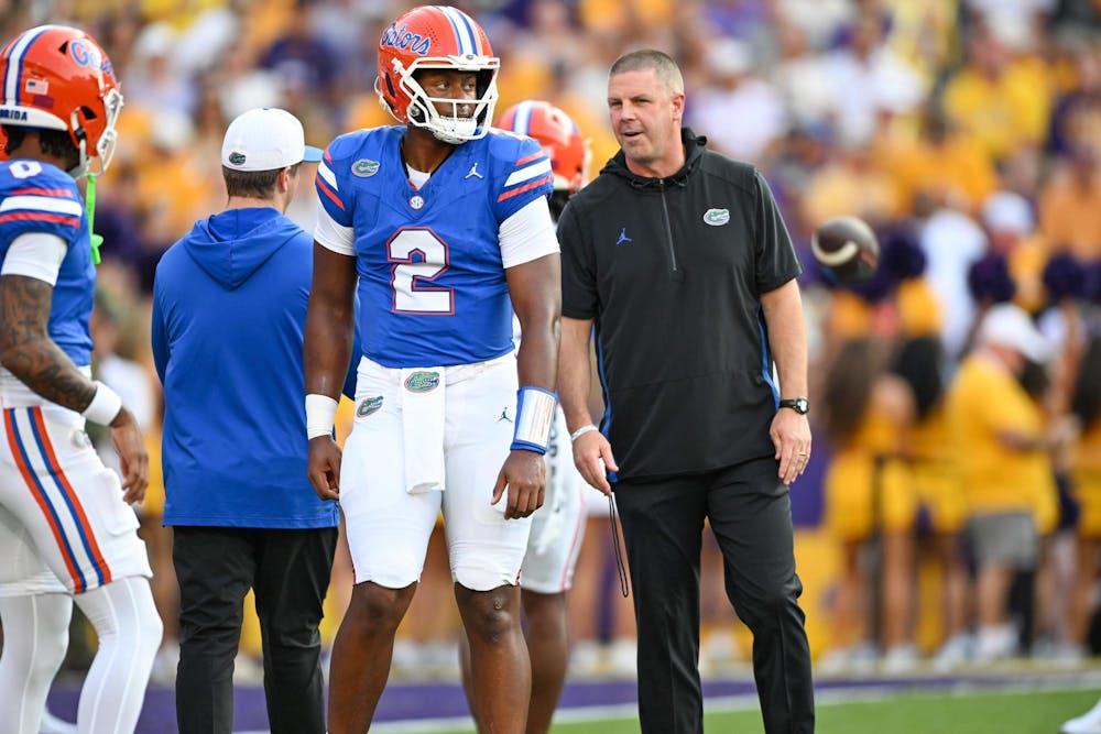 Florida Gators quarterback DJ Lagway (2) and head coach Billy Napier talk during warmups before a football game between the Louisiana State Tigers and the Florida Gators on Saturday, Sept. 13th, 2025, at Tiger Stadium in Baton Rouge, La.