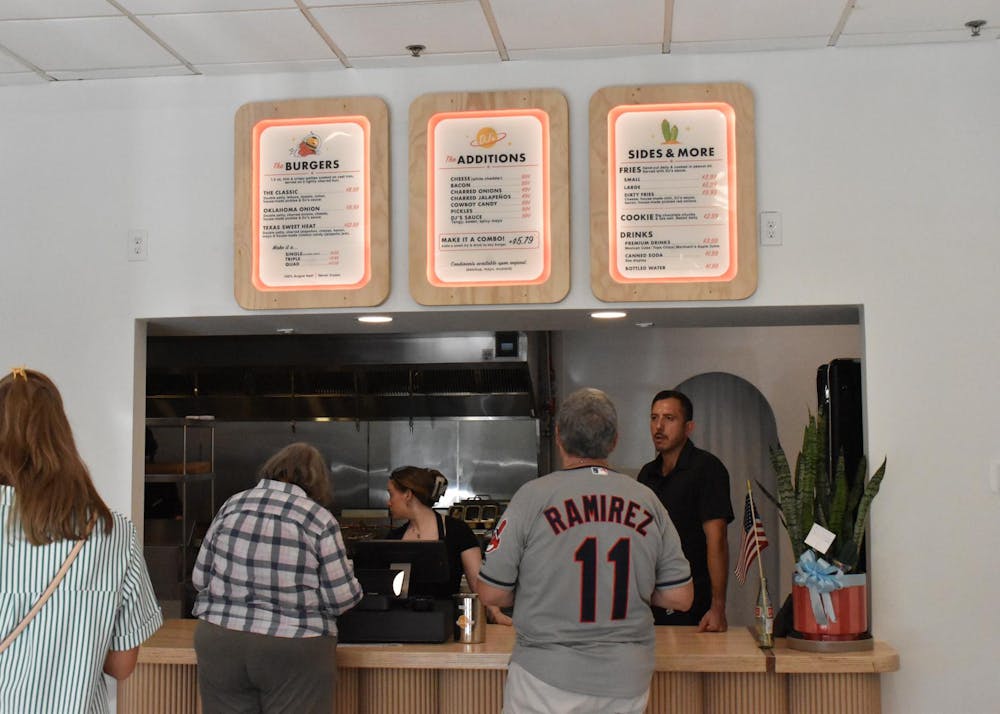 Customers look over the menu of DJ's Cast Iron Burgers Wednesday, July 8, 2026 in Gainesville, Fla.