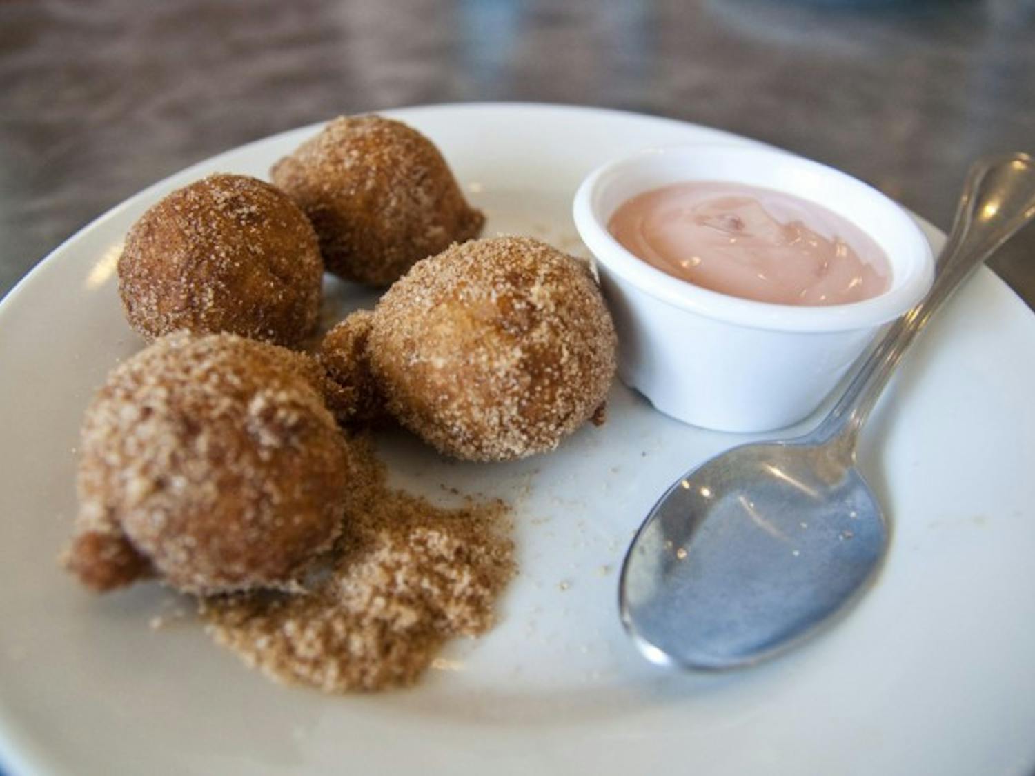 The Apple Fritters at Peach Valley Cafe are brought to the table in a brown paper bag, shaken up in sugar and cinnamon and served on a plate with a yogurt dipping sauce.