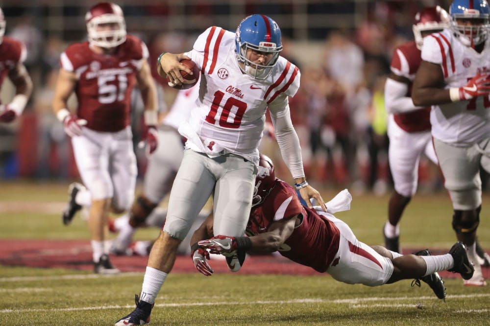 Mississippi's quarterback Chad Kelly (10) tries to run through the tackle of Arkansas' defensive back Josh Liddell (28) in the second half of an NCAA football game Saturday, Oct. 15, 2016, in Fayetteville, Ark. Arkansas beat Mississippi 34-30. (AP Photo/Chris Brashers)