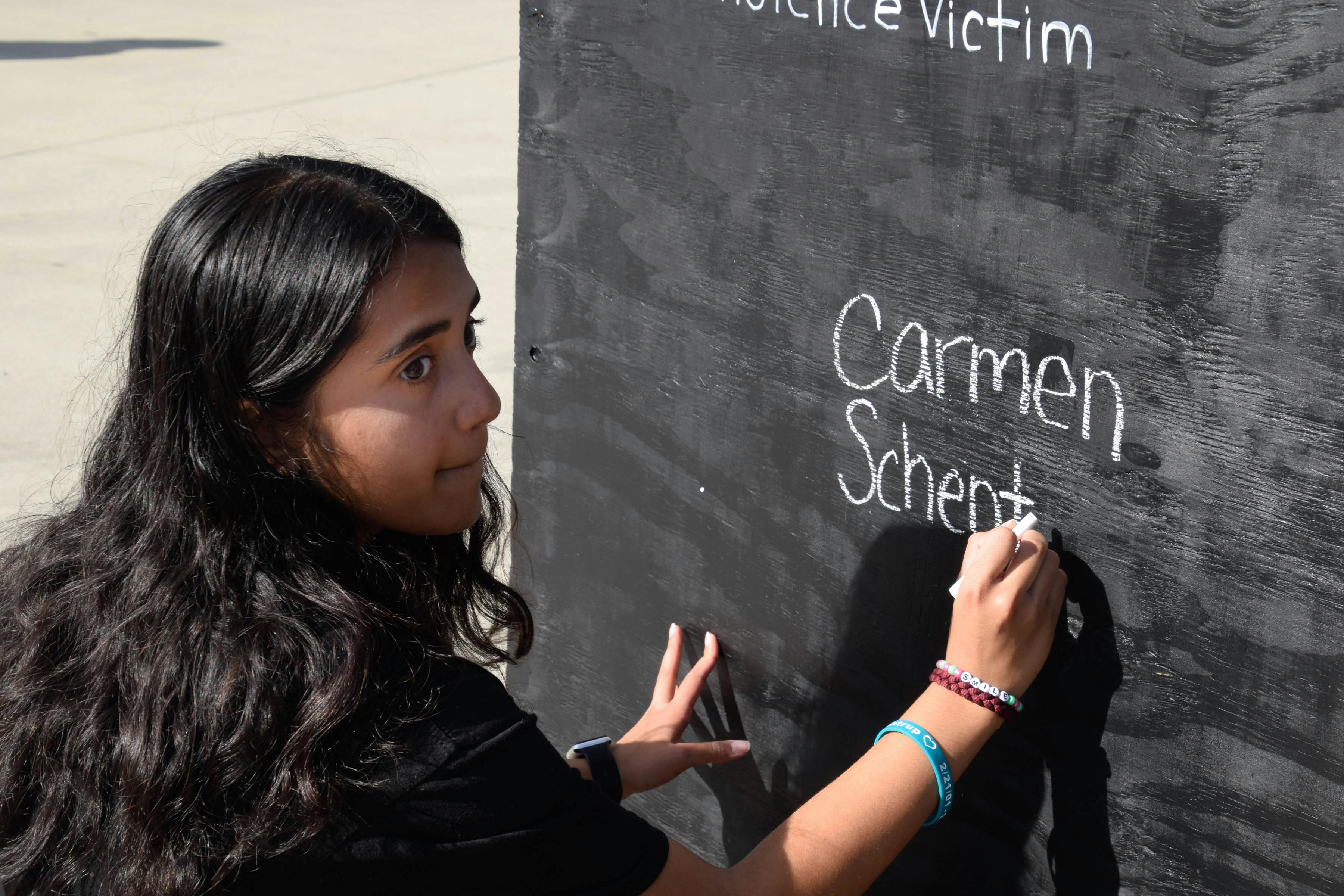 MSD alum Anisha Saripalli, an 18-year-old biomedical engineering sophomore and the March for Our Lives Gainesville treasurer, writes the name of her friend down on the gun violence victim board. Carmen Schentrup was a Marjory Stoneman Douglas student who died in the shooting just days after she was accepted into UF.