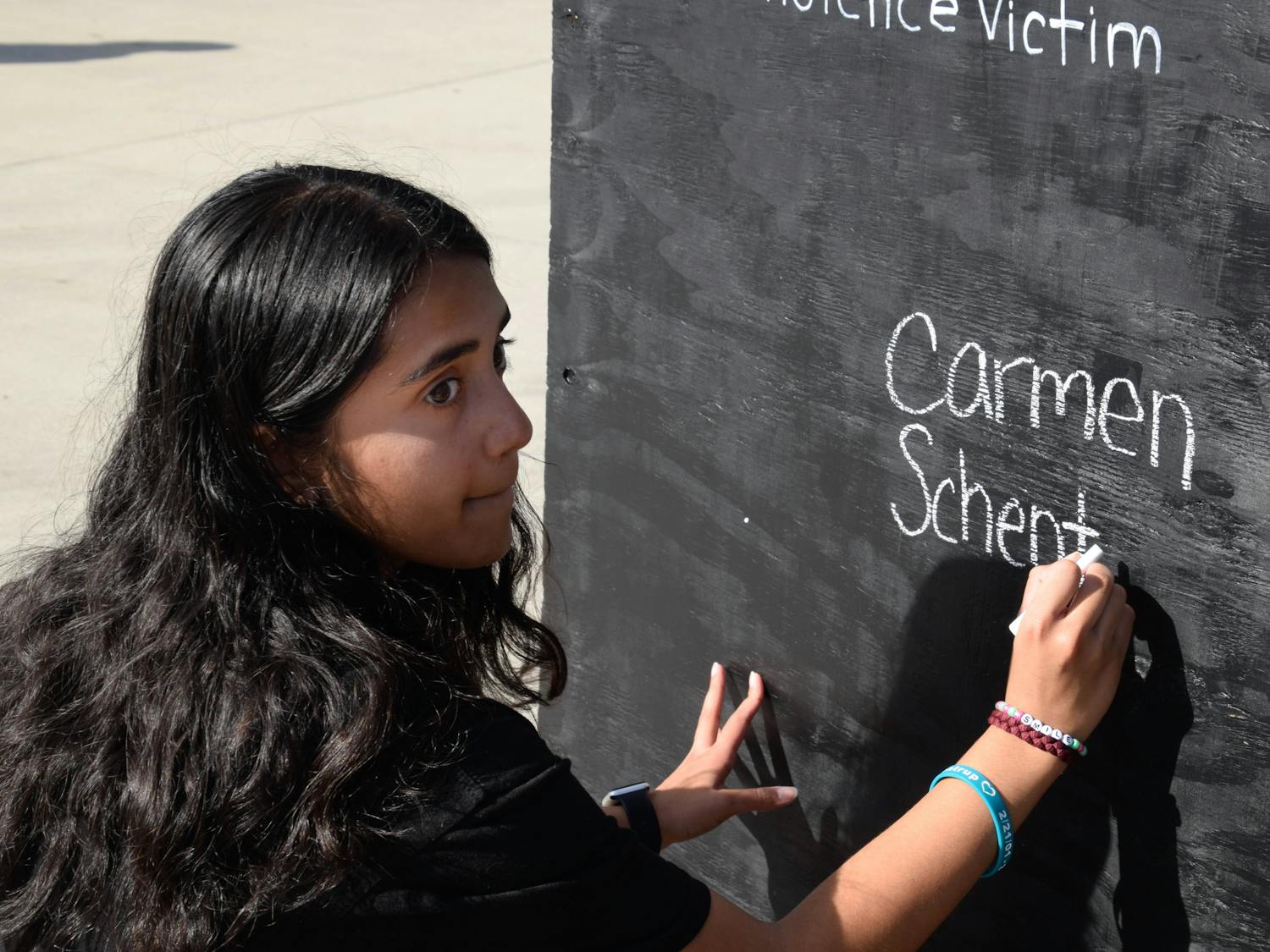 MSD alum Anisha Saripalli, an 18-year-old biomedical engineering sophomore and the March for Our Lives Gainesville treasurer, writes the name of her friend down on the gun violence victim board. Carmen Schentrup was a Marjory Stoneman Douglas student who died in the shooting just days after she was accepted into UF.