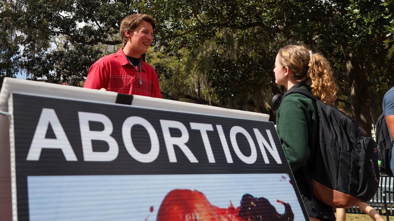 Madoc, a high-schooler from Columbus, OH, shares pamphlets about abortion to UF students on Plaza of the Americas, March 6, 2026 in Gainesville, Fla.
