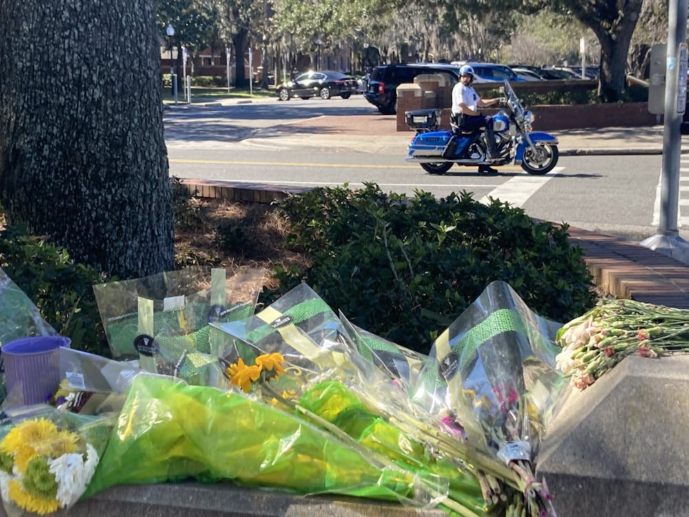 GPD officer on a motorcycle stops at the intersection of Buckman Drive and West University Avenue, where a car crash involving a UF student took place two weeks ago.