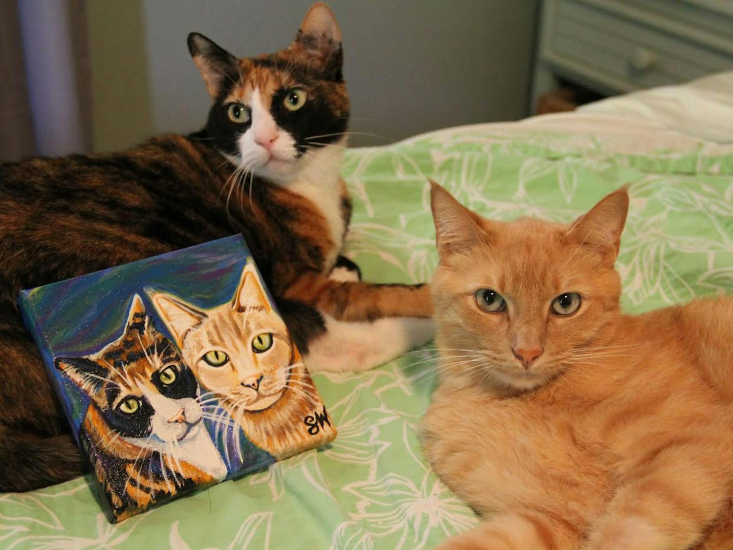 Oka and Mango posing with their commissioned Samm Wehman Art Pet Portrait. (Courtesy by Samm Epstein)