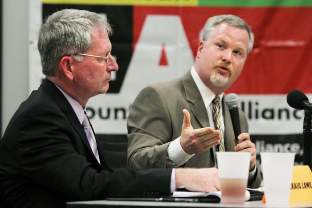 <p>Gainesville mayor Craig Lowe listens to opponent Ed Braddy’s rebuttal during a candidate forum at the Alachua County Health Department on Monday night. Read the story on page 4.</p>