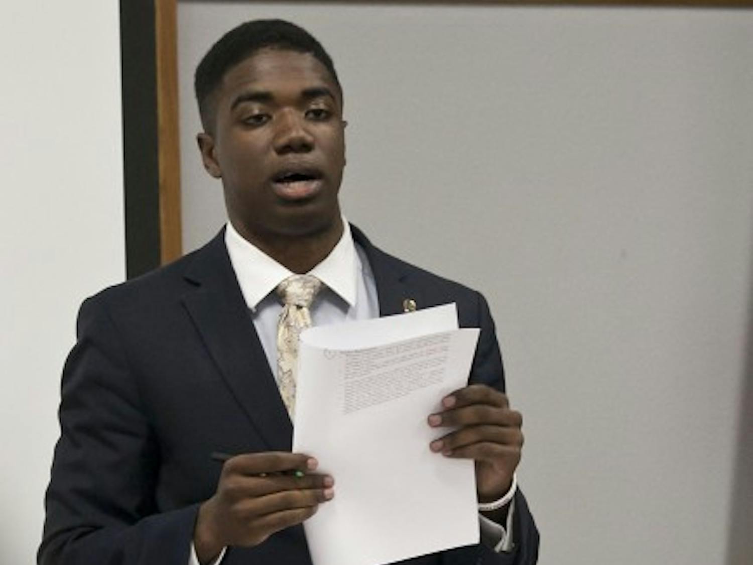 STUDENT SENATE -- Senate President Aundre Price provides copies of Rule XIII Censure, Expulsion and Officer Removal Tuesday at UF's Senate meeting after receiving complaints about senator behavior during the meeting May 29. He told senators to follow the procedures described in the rules if he or she wishes for another senator to be censored or removed.