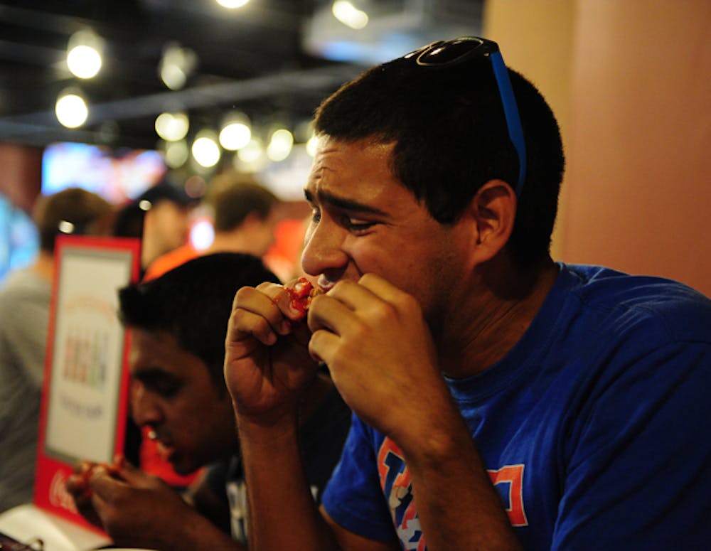 <p>Jorge Araujo, a 21-year-old mechanical and aerospace engineering senior, and Amit Gupta, a Ph.D. candidate in electrical engineering, participate in the Munchies 420 ghost pepper chili wing eating challenge. Neither could finish his plate.</p>