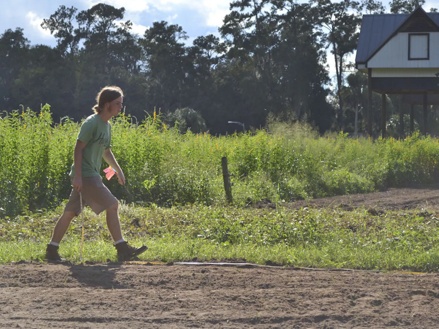 Patrick Hunt, a 21-year-old organic crop production senior, measures out a plot of land at the Student Agricultural Gardens on Oct. 5, 2015, for a cover crop of fava beans. The garden intern said cover crops help keep the soil from eroding while they are not using the land. The cool October afternoon set the scene for Hunt to plant the fava bean seeds with The Gator Gardening Club.