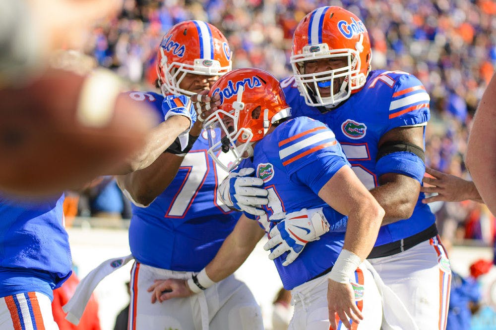 <p>Max Garcia and Chaz Green celebrate with Mike McNeely after his touchdown during Florida's 38-20 win against Georgia on Saturday</p>