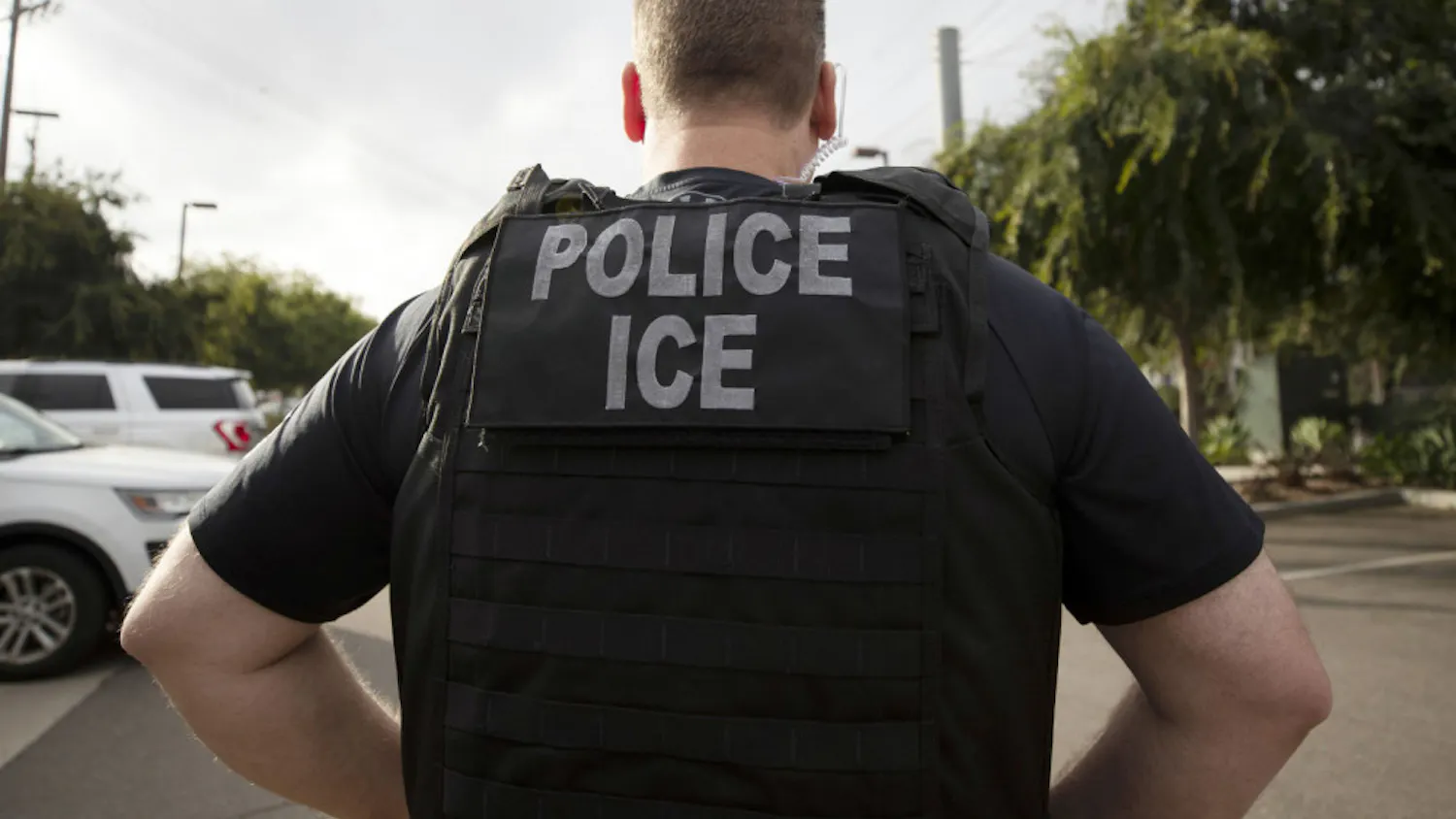 FILE - In this July 8, 2019, file photo, a U.S. Immigration and Customs Enforcement (ICE) officer looks on during an operation in Escondido, Calif. International students will be forced to leave the U.S. or transfer to another college if their schools offer classes entirely online this fall, under new guidelines issued Monday by federal immigration authorities. The guidelines, issued by U.S. Immigration and Customs Enforcement, provide additional pressure for campuses to reopen even amid growing concerns about recent spread of COVID-19 among young adults. (AP Photo/Gregory Bull, File)
