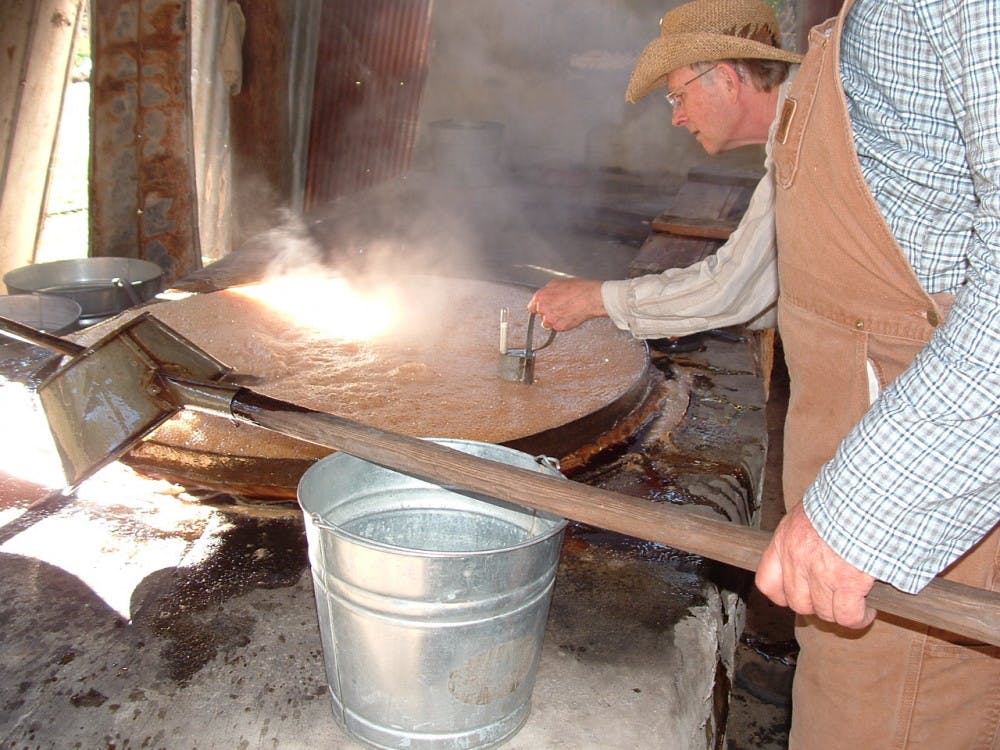<p class="p1">Bill Dunk, a volunteer at Dudley Farm Historic State Park, bottles cane syrup at the park’s annual Cane Day.</p>