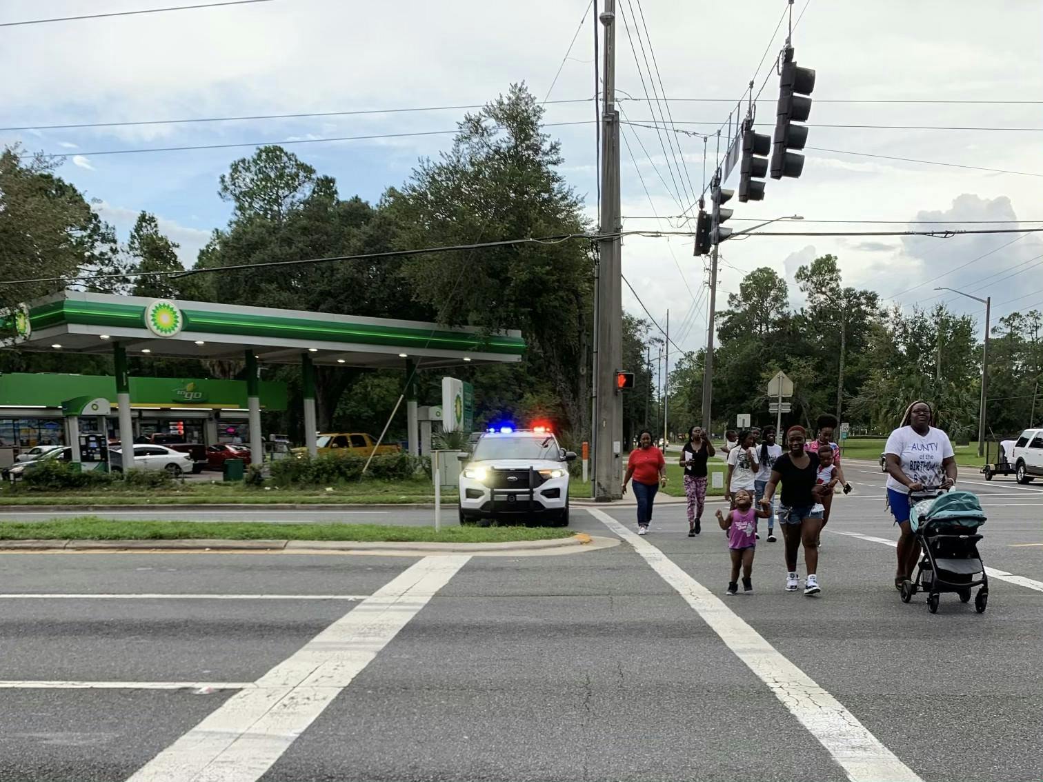 Residents attending a walking teach-in for Terrell Bradley cross Northeast 15th Street Saturday, July 23, 2022.
