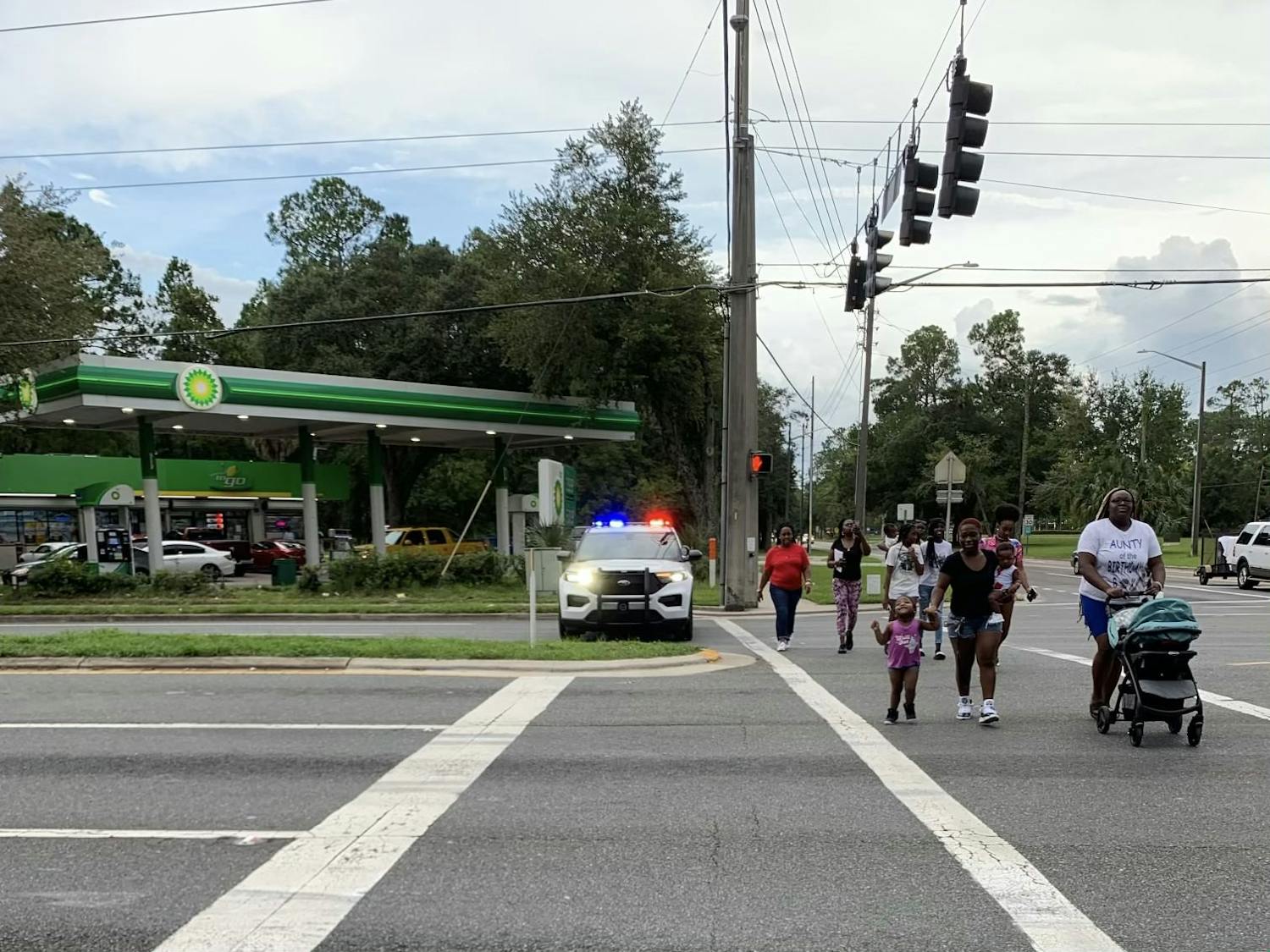 Residents attending a walking teach-in for Terrell Bradley cross Northeast 15th Street Saturday, July 23, 2022.