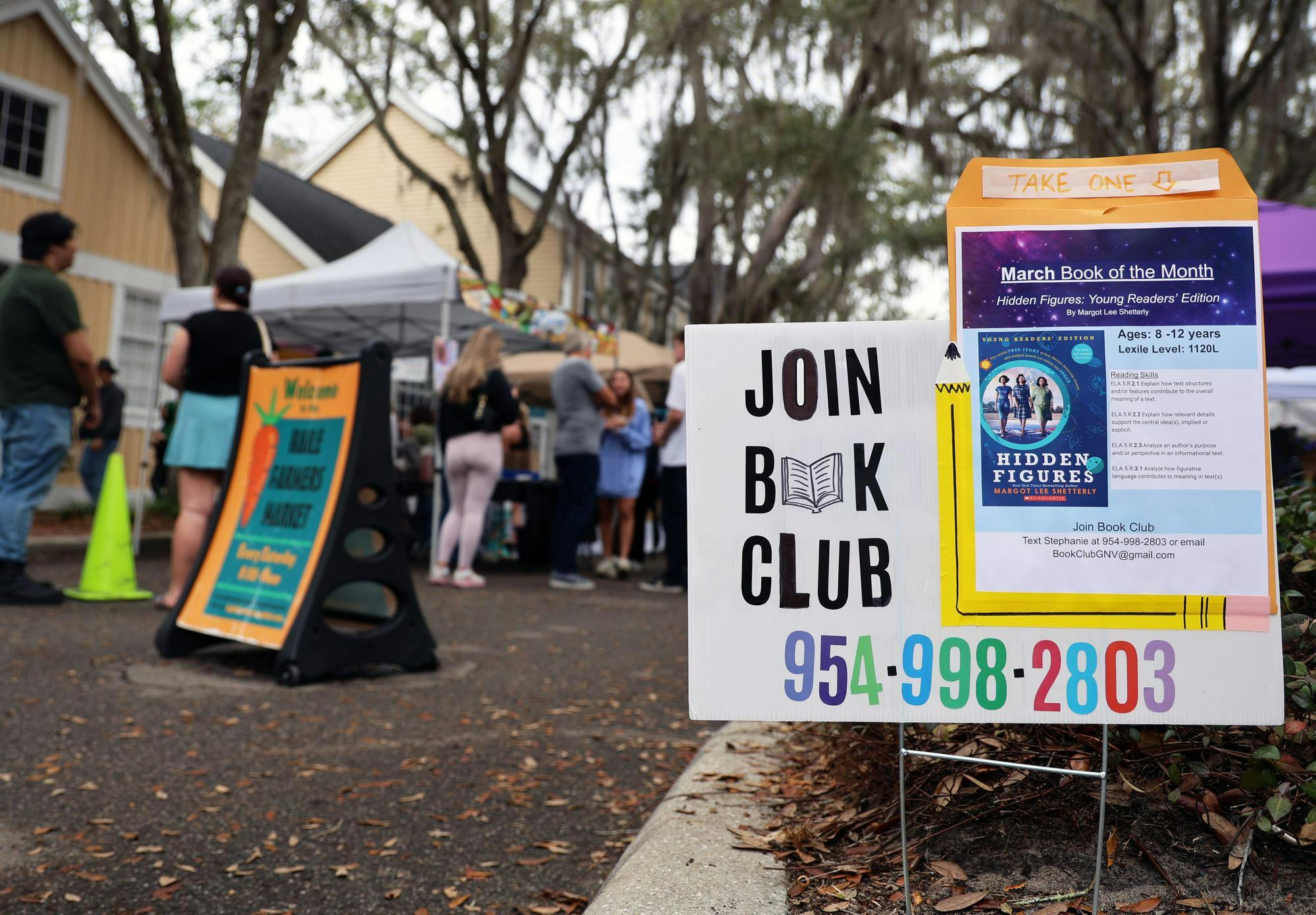 A sign advertising a book club is displayed during the Haile Farmers Market in Gainesville, Fla., Saturday, Feb. 28, 2026. 