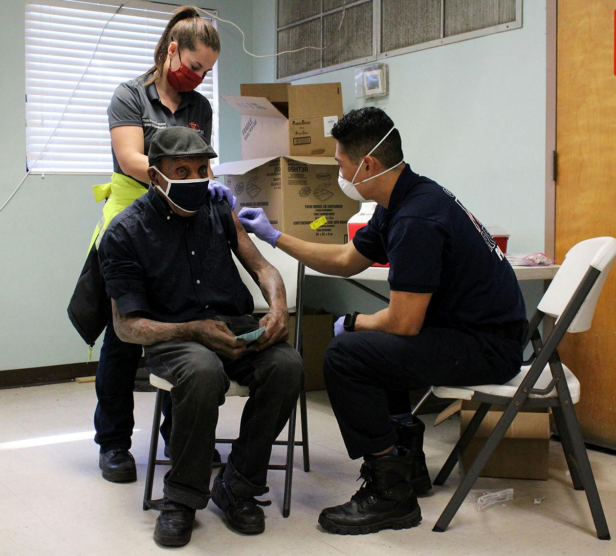 Joe Harris, a 91-year-old homeless person, receives his second dose of the Moderna COVID-19 vaccine on Wednesday, March 10, 2021. Vaccines were given to St. Francis House staff members and homeless people by Gainesville Fire Rescue firefighters and paramedics.