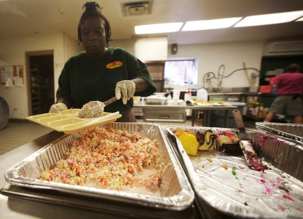 <p>Volunteer Lavonne Smoke prepares a food tray for the hungry at St. Francis House on Tuesday. Smoke said she tries to volunteer at the soup kitchen every day.</p>