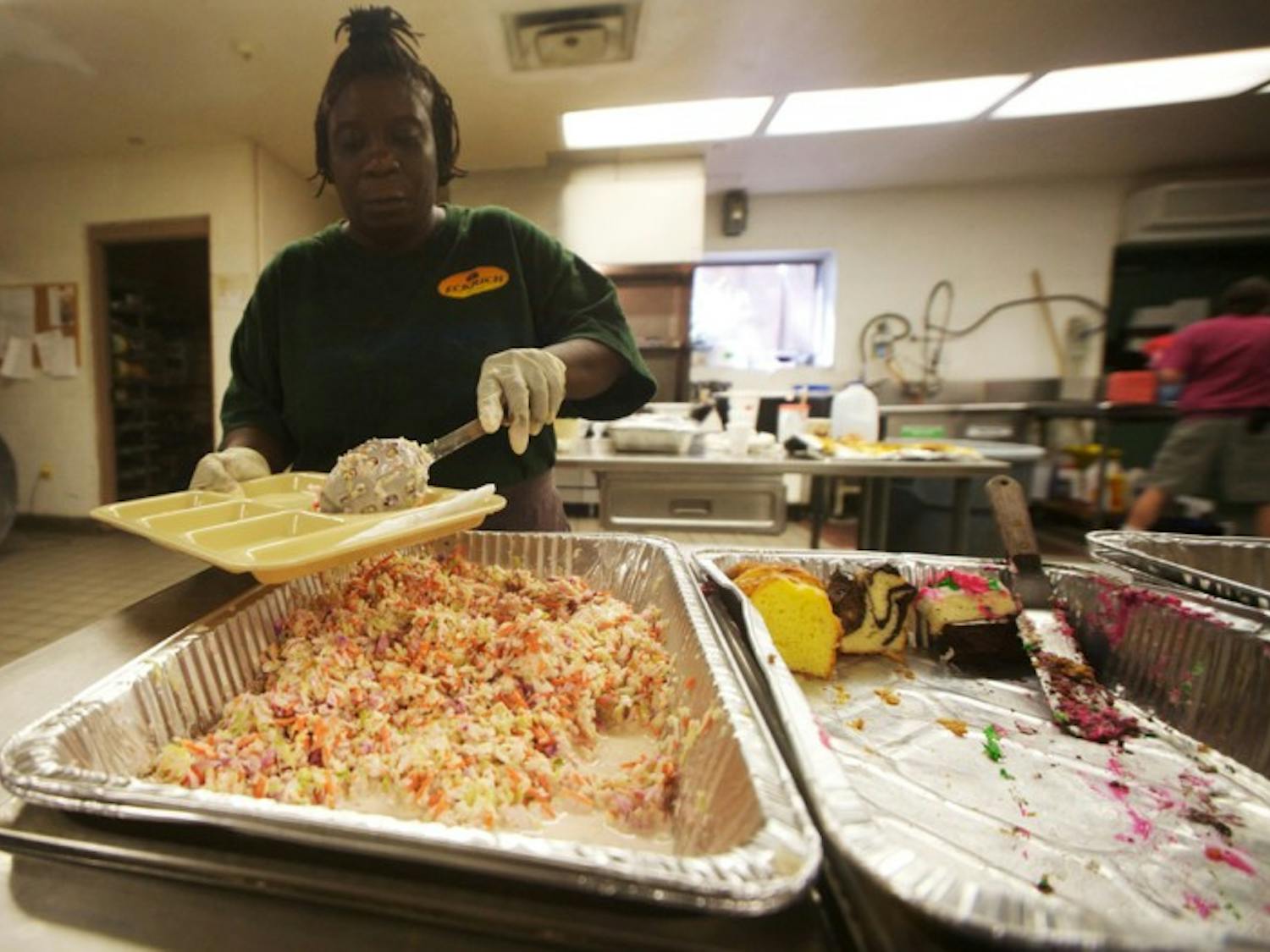 Volunteer Lavonne Smoke prepares a food tray for the hungry at St. Francis House on Tuesday. Smoke said she tries to volunteer at the soup kitchen every day.