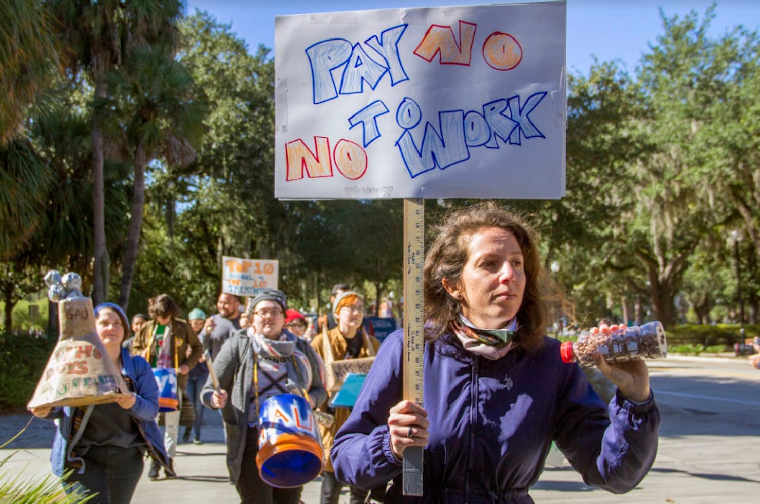 Shaking a bottle of peanuts, Paula Fernandez, a 31-year-old UF teaching assistant, protests fees for employees of the university&nbsp;
