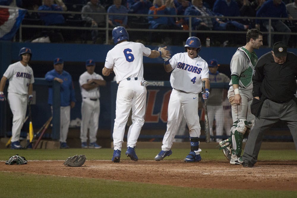 <p>Mike Rivera, right, congratulates Jonathan India after he scored the eventual game-winning run during Florida's 5-4 win over William and Mary on Feb. 17, 2017, at McKethan Stadium. </p>