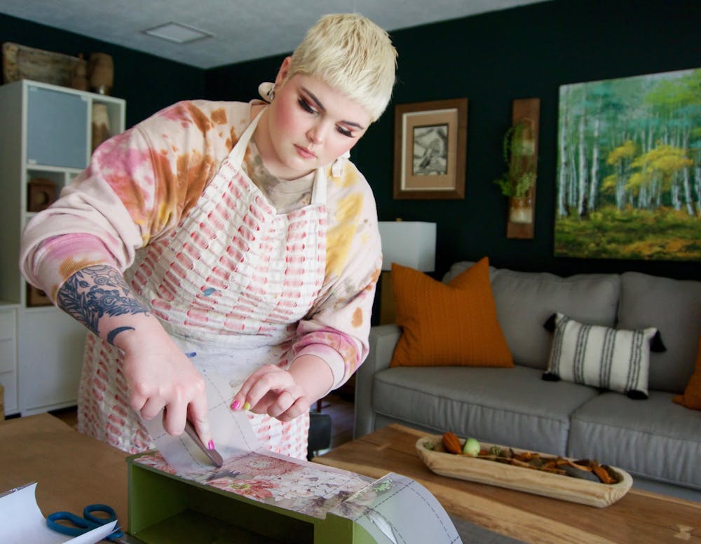 <p>Chase Morris, 25, a Gainesville resident and DIY content creator applies transfers to an antique sewing machine drawer to repurpose into a planter on Tuesday, June 8, 2021. </p>